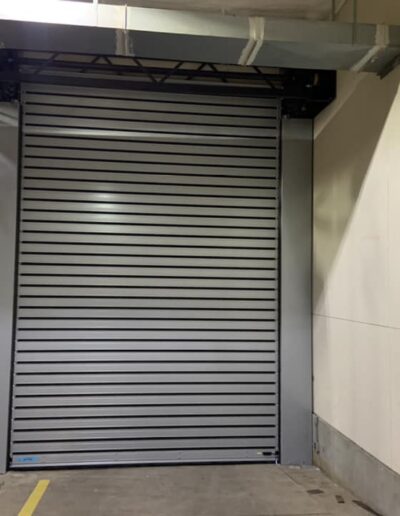 A large metal roller door is prominently displayed in a spacious warehouse setting, showcasing industrial architecture.