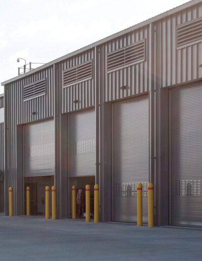 A large industrial building featuring multiple expansive doors, showcasing its functional design and spacious structure.